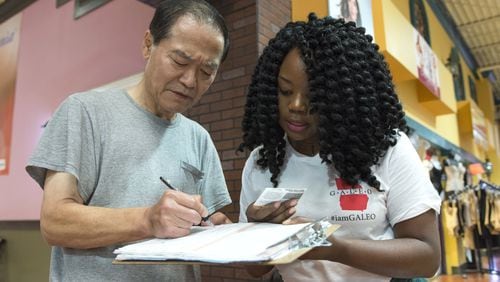 October 7, 2016, Duluth - Victoria Arzu, 28, right, from Lawrenceville, Georgia, helps Gold Pak, 66, left, from Doraville, Georgia, register to vote in Duluth, Georgia, on Friday, October 7, 2016. Arzu works for the Georgia Association of Latino Elected Officials, which is encouraging individuals in minority communities to register to vote. (DAVID BARNES / DAVID.BARNES@AJC.COM)