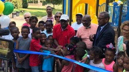 A ribbon-cutting for a new playground at Midway Park near Memorial Drive was held July 27. DeKalb Commissioner Larry Johnson is pictured in the center, joined by Commissioner Greg Adams and DeKalb Interim Parks Director Marvin Billups.