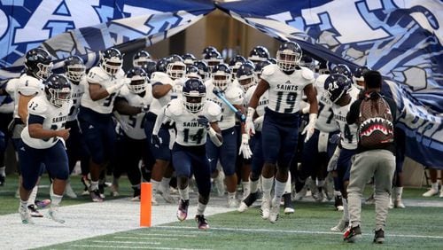 Cedar Grove players run onto the field before their game against Peach County in the Class AAA State Championship at Mercedes-Benz Stadium, Tuesday, December 11, 2018, in Atlanta. (Jason Getz/Special to the AJC)