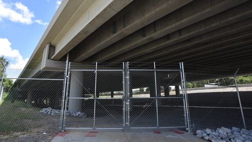 A fence was installed under the new section of I-85, which was rebuilt after the fire March 30. HYOSUB SHIN / HSHIN@AJC.COM