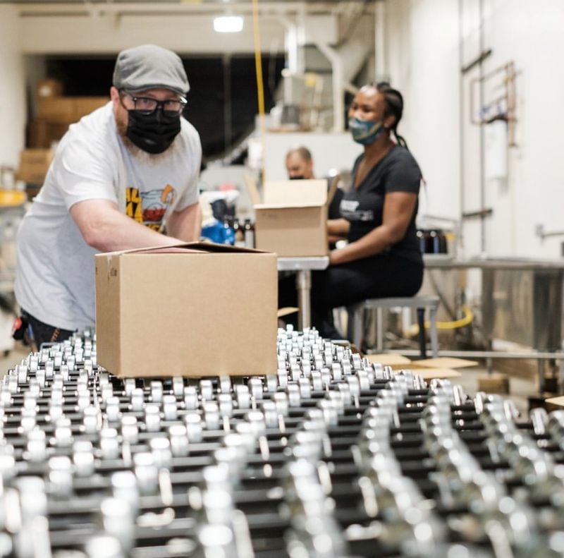 Patrick Shriver (left) and Siedah Mabry work the packaging line at Proof Syrup’s facility off Howell Mill Road. Courtesy of Caleb Arias