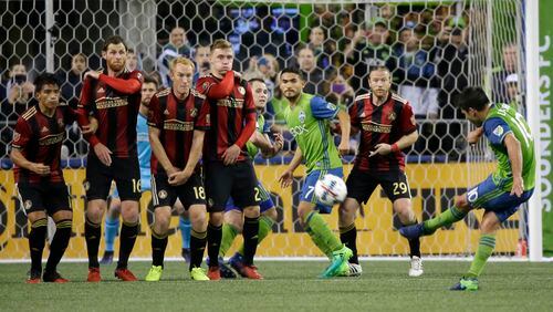 Atlanta United players make a wall as Seattle Sounders forward Nicolas Lodeiro, right, takes a free kick in the first half of an MLS soccer match, Friday, March 31, 2017, in Seattle. (AP Photo/Ted S. Warren)