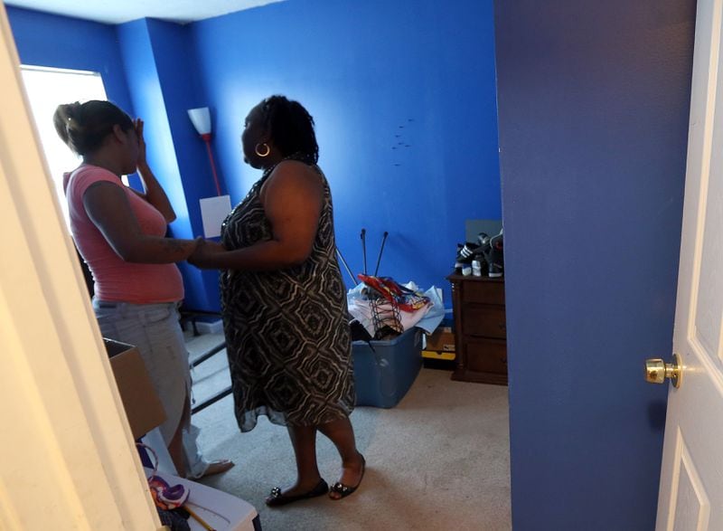 His mother, Adrienne Rodriguez (left), and grandmother, Alice Stout-Osorio, become emotional after going into 13-year-old Nizzear Rodriguez's bedroom after his fatal shooting in 2014. 