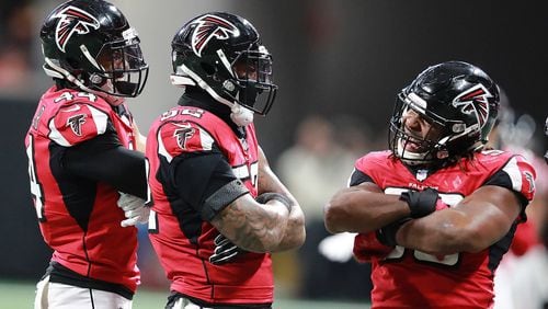 Vic Beasley Jr. (from left), Bruce Irvin, and Steven Means of the Falcons react by crossing their arms after Irvin sacked Cardinals quarterback Josh Rosen on Sunday, Dec 16, 2018, in Atlanta.   Curtis Compton/ccompton@ajc.com