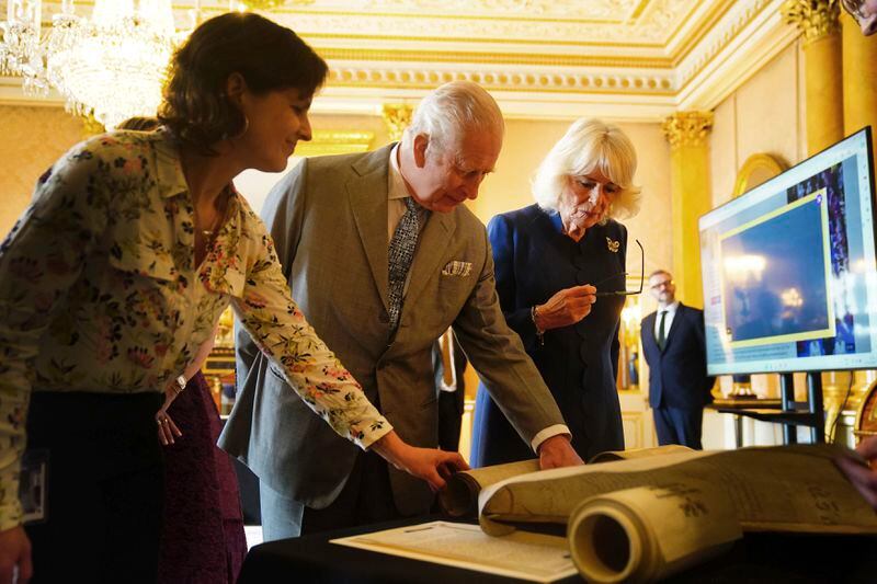 EMBARGOED TO 2200 THURSDAY MAY 2 King Charles III and Queen Camilla are shown Coronation Rolls of previous monarchs after being presented with their own Coronation Roll, an official record of their Coronation, at Buckingham Palace, central London. Picture date: Wednesday May 1, 2024. King Charles III gaped at the 70-foot-long (21.4-meter) hand-lettered scroll as it was presented to him earlier this week at Buckingham Palace, thanking the artisans who produced the document that serves as the official record of his coronation almost a year ago. (Victoria Jones/PA via AP)