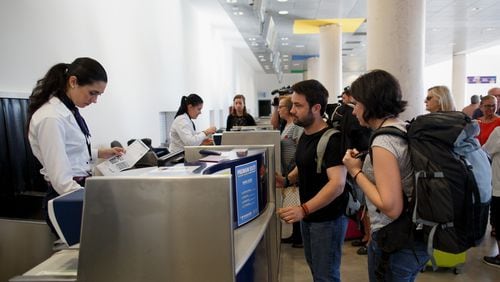 Passengers check-in for their flight at an airport. (Photo by Pablo Blazquez Dominguez/Getty Images)