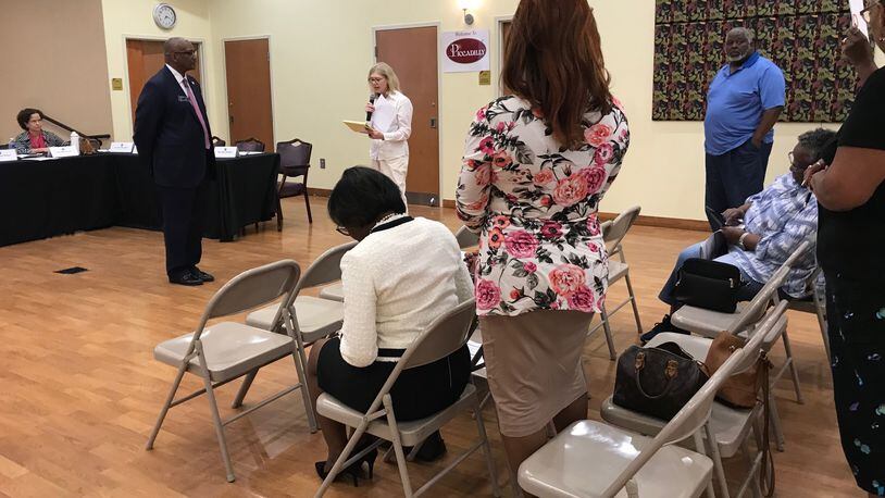 State Sen. Emanuel Jones, D-Lithonia (standing at left) listens to public comment from Mary Hinkel (center, in white) during the DeKalb County Delegation's town hall meeting on Sept. 16, 2019. Other members of the audience stand in support of Hinkel, who opposes the ethics referendum. (TIA MITCHELL/TIA.MITCHELL@AJC.COM)