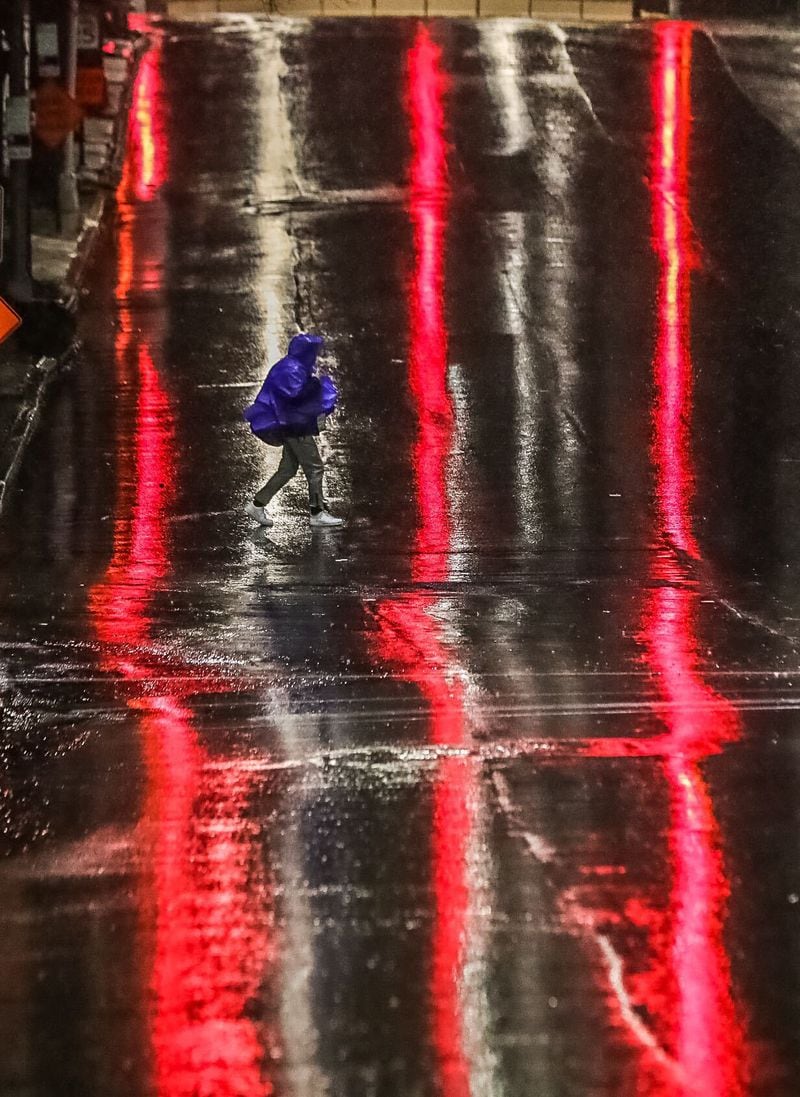 An early-morning walker braves the rain in metro Atlanta.