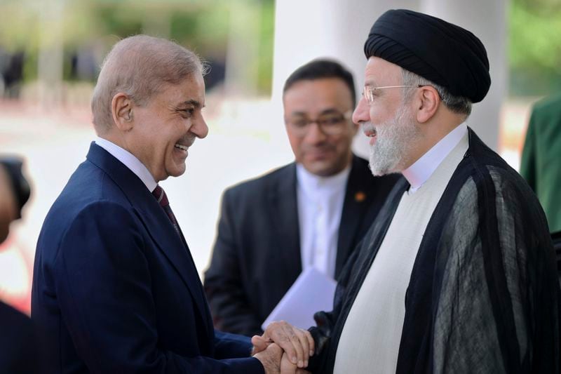 In this photo released by Prime Minister Office, Pakistan's Prime Minister Shehbaz Sharif, left, greets to Iranian President Ebrahim Raisi upon his arrival in the prime minister house in Islamabad, Pakistan, Monday, April 22, 2024. (Prime Minister Office via AP)