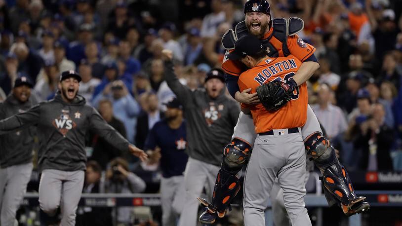 Houston Astros catcher Brian McCann leaps in the arms of starting pitcher Charlie Morton after Game 7 of baseball's World Series against the Los Angeles Dodgers Wednesday, Nov. 1, 2017, in Los Angeles. The Astros won 5-1 to win the series 4-3.