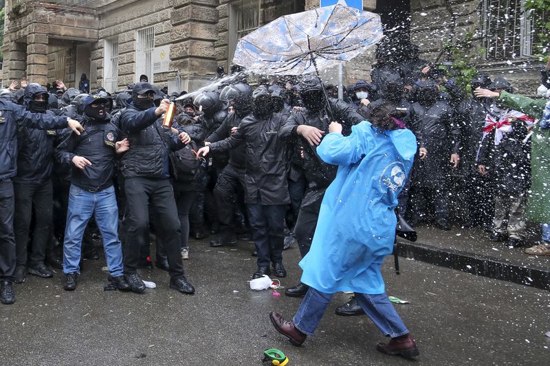 Police use a spray trying to block demonstrators near the Parliament building during an opposition protest against "the Russian law" in the center of Tbilisi, Georgia, on Monday, May 13, 2024. Daily protests are continuing against a proposed bill that critics say would stifle media freedom and obstruct the country's bid to join the European Union. (AP Photo/Zurab Tsertsvadze)