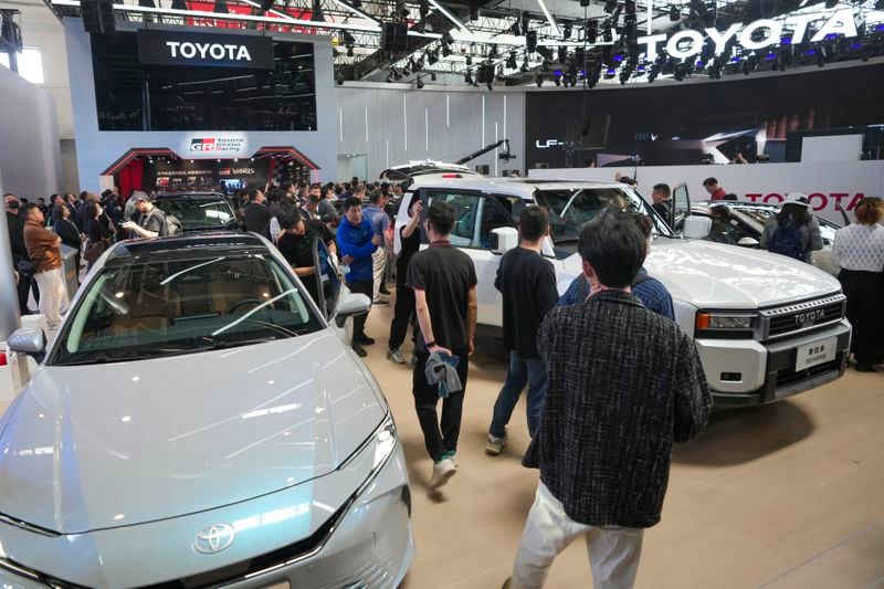 Visitors look at Toyota cars during the opening of China Auto Show in Beijing, China, Thursday, April 25, 2024. (AP Photo/Tatan Syuflana)