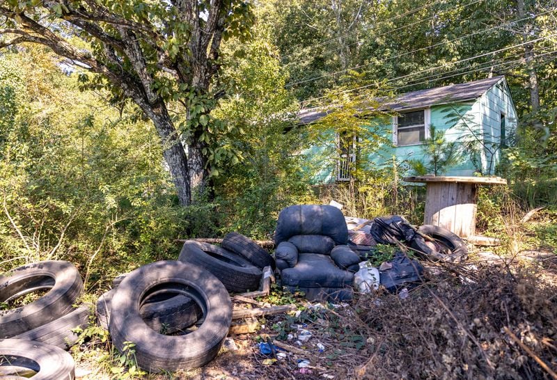 Stonecrest has several locations, including this abandoned home on Maddox Road near Rogers Lake Road, where illegal dumping and overflow parking is adjacent to abandoned, overgrown homes. Wednesday, Sept 29, 2021.   (Jenni Girtman for The Atlanta Journal-Constitution)