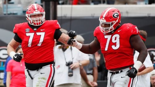 Georgia Bulldogs offensive tackle Cade Mays (77) and Georgia Bulldogs offensive lineman Isaiah Wilson (79) fist bump after Georgia Bulldogs wide receiver Jeremiah Holloman (9) scored the Bulldogs first TD on a pass from  Georgia Bulldogs quarterback Jake Fromm (11). The University of Georgia Bulldogs defeated the Florida Gators 36-17 in a NCAA college football game Saturday, Oct. 27th, 2018, at TIAA Bank Field in Jacksonville, FL.      BOB ANDRES / BANDRES@AJC.COM