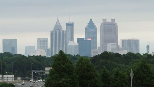 Trees sit below the Atlanta skyline as cars drive by on June 12, 2019. Cities across metro Atlanta are rewriting tree ordinances to protect Atlanta’s diminishing tree canopy, which is threatened by clear-cutting for new builds in and around the city. (credit: Christina Matacotta/christina.matacotta@gmail.com)