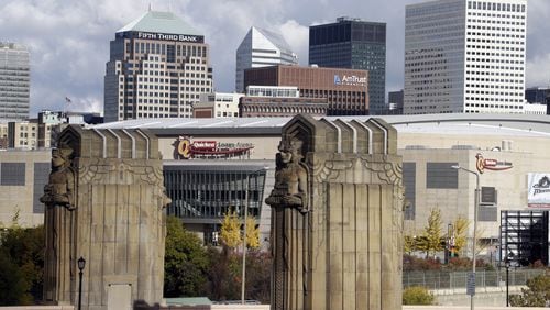 FILE - This Nov. 8, 2013, file photo shows Cleveland's skyline and the venue of the 2016 Republican National Convention, Quicken Loans Arena, framed by the Guardians of Traffic sculptures at the east end of the Hope Memorial Bridge in Cleveland. Donald Trump's effort to unite a splintered Republican Party around his candidacy is about to take center stage in a city that is itself deeply fractured. (AP Photo/Mark Duncan, File)