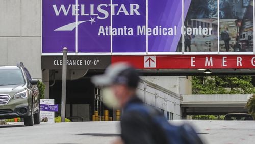 A man walks past Wellstar Atlanta Medical Center in Atlanta on Wednesday. The Wellstar system has announced it is furloughing more than 1,000 employees across its network. (JOHN SPINK/JSPINK@AJC.COM)