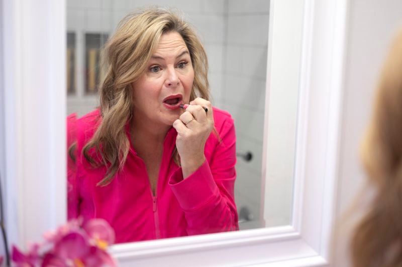 Actress and singer Lisa Donahey applies her make-up at her home in the Sherman Oaks section of Los Angeles on Tuesday, April 16, 2024. Her weight has since dropped to a little less than 190 pounds. Having used the medication to give her “a kick-start,” Donahey said she plans to wean herself off Mounjaro once she loses another 40 pounds. (AP Photo/Richard Vogel)