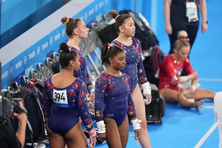 Jordan Chiles, with her back turned away from camera, Simone Biles, center, Grace McCallum and Sunisa Lee, of the United States, wait on the side during women's qualification for the Artistic Gymnastics final at Ariake Gymnastics Center in Tokyo on Sunday