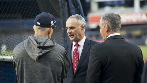 Major League Baseball Commissioner Rob Manfred talks with New York Yankees manager Joe Girardi before the American League Wild Card game against the Minnesota Twins at Yankee Stadium in New York on Tuesday, Oct. 3, 2017. (Howard Simmons/New York Daily News/TNS)