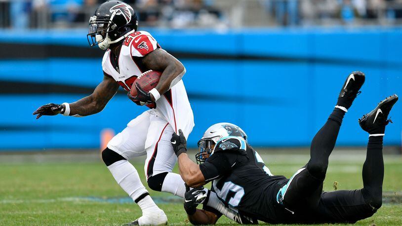 Tevin Coleman  of the Atlanta Falcons runs the ball against Eric Reid  of the Carolina Panthers in the third quarter during their game at Bank of America Stadium on December 23, 2018 in Charlotte, North Carolina. (Photo by Grant Halverson/Getty Images)