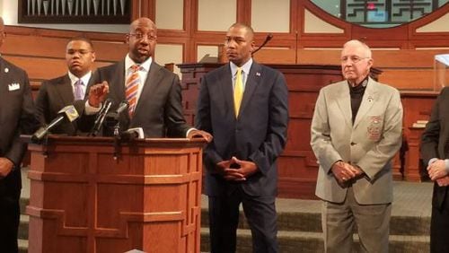 Ebenezer Baptist Church Senior Pastor Raphael Warnock speaks about record restrictions Monday at the church, while other supporters, including Fulton County District Attorney Paul Howard (left) look on. ARIELLE KASS/AKASS@AJC.COM