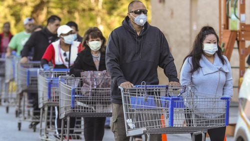 Mask-wearing shoppers lined up over the length of a football field at the Sam’s Club on Clairmont Road in DeKalb County on April 3, 2020. JOHN SPINK/JSPINK@AJC.COM