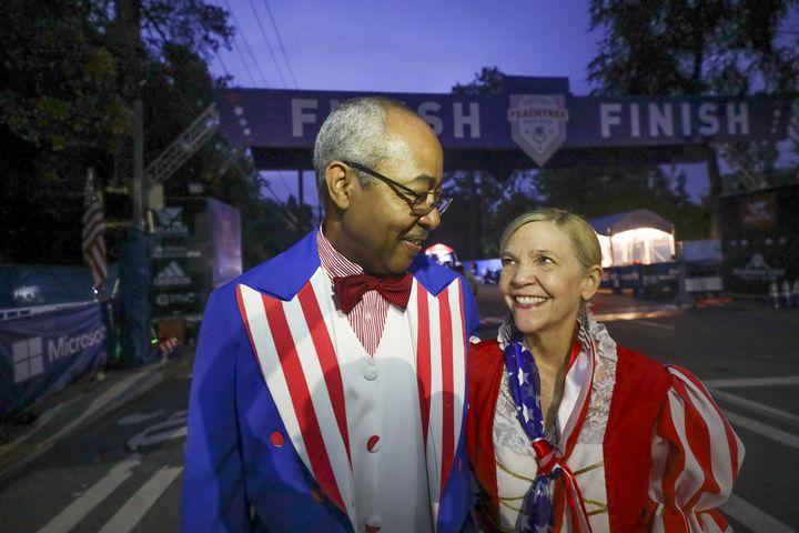 Reg and Paula Barnes are dressed as Uncle Sam and Betsy Ross arrive to staff the finish line at the 53rd running of the Atlanta Journal-Constitution Peachtree Road Race in Atlanta on Monday, July 4, 2022. (Curtis Compton / Curtis.Compton@ajc.com)