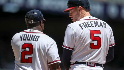 Braves first base coach Eric Young (left) talks with Freddie Freeman during a 2019 game.   (ALYSSA POINTER/ALYSSA.POINTER@AJC.COM)