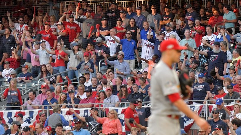 Despite the Braves’ front office not promoting the tomahawk chop in Game 5, fans did it anyway before St. Louis Cardinals starting pitcher Jack Flaherty, right, delivered a pitch in the fourth inning. HYOSUB SHIN / HYOSUB.SHIN@AJC.COM