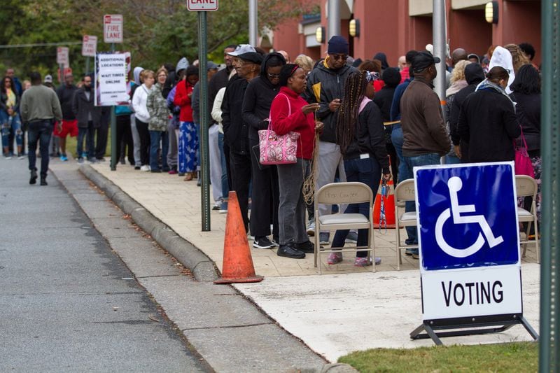 People wait in a long line to vote on Saturday, Oct. 27, 2018, at the Cobb County Board of Elections and Registration office in Marietta. 