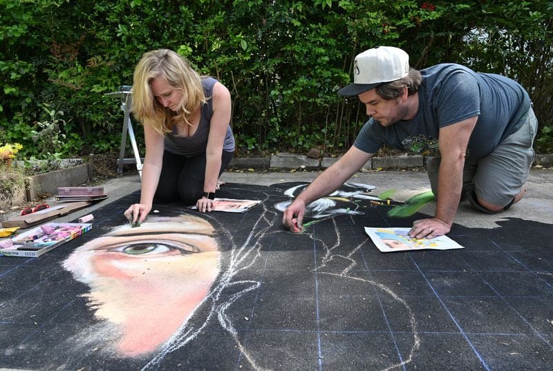 Jessi Queen and her husband Zach Herndon draw a mammoth mural of a friend who is an anesthesiologist working with COVID patients. When their portion of the portrait is done, it will be virtually stitched together with those of other artist friends in Seattle, Houston and California, and presented to the doctor in a stop-action video. Hyosub Shin / Hyosub.Shin@ajc.com
