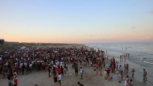 A large crowd of people enjoy the Tybee beach at sunset during Orange Crush on Saturday. (Photo Courtesy of RJ Smith/Savannah Morning News)