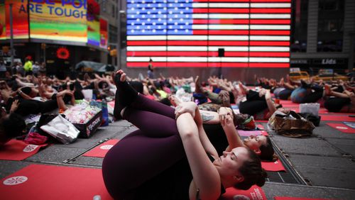 NEW YORK, NY - JUNE 21: People do yoga in Times Square as part of the International Day of Yoga celebration on the Summer Solstice June 21, 2015 in New York City. One hundred and ninety-two countries joined in for a mass yoga session to mark the United Nations declared, International Yoga Day. (Photo by Kena Betancur/Getty Images)