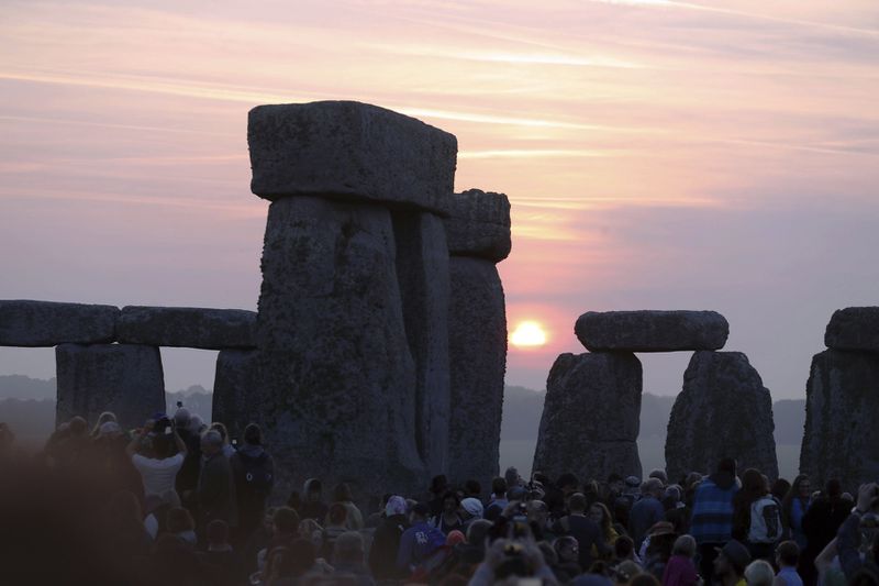 Some thousands of people watch the sun rise while standing among the ancient stones at Stonehenge, to celebrate the Summer Solstice at Stonehenge in Salisbury, England, early Wednesday June 21, 2017.  The prehistoric monument, Stonehenge is about 5000-years old and is thought to have been constructed to mark the movement of the sun and other heavenly objects according to Pagan rites. (Steve Parsons/PA via AP)