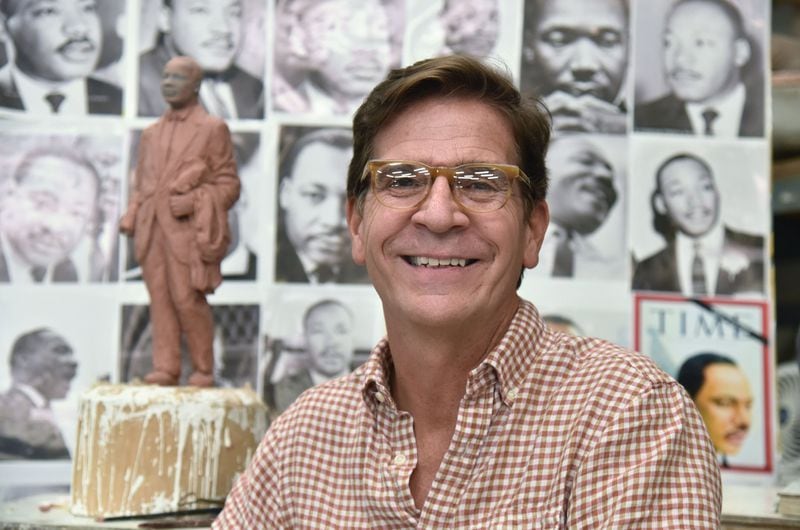 Sculptor Martin Dawe in front of a maquette, or model, and a wall of pictures he used to create the likeness of Martin Luther King Jr. in his studio. The statue will be unveiled on the grounds of the state Capitol Monday. HYOSUB SHIN / HSHIN@AJC.COM