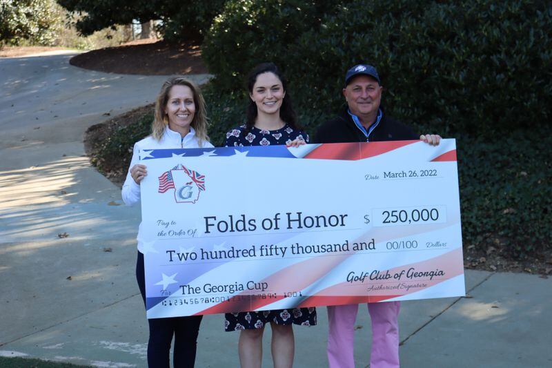 (L-R) Folds of Honor representative Sara Bush, speaker and recipient Liz O'Hare accept a check for $250,000 from Golf Club of Georgia committee member Bill Freitag for academic scholarships.