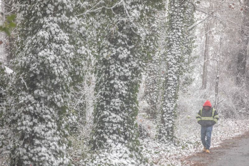 A man walks as snow falls on Sunday, Jan. 16, 2022, in Acworth, Ga. (BRANDEN CAMP FOR THE ATLANTA JOURNAL-CONSTITUTION)