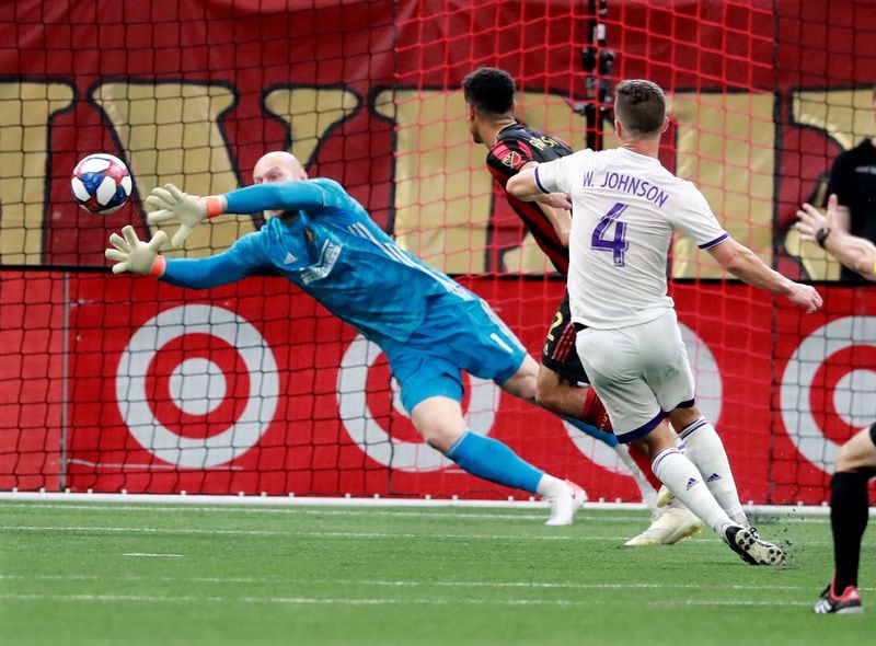 Atlanta United goalkeeper Brad Guzan blocks a shot by Orlando City defender Will Johnson Sunday, May 12, 2019, in Atlanta. 