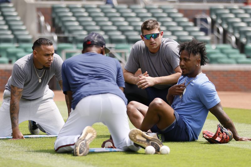 Braves infielders Orlando Arcia, Austin Riley, and Ozzie Albies interact with Braves third-base coach Ron Washington before the game against the Colorado Rockies at Truist Park on Sunday, June 18, 2023, in Atlanta. Miguel Martinez / miguel.martinezjimenez@ajc.com 