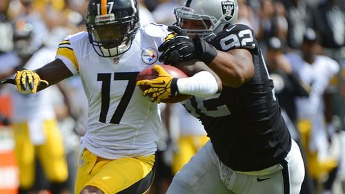 Former Raiders defensive lineman Richard Seymour, who played collegiately at the University of Georgia, catches Mike Wallace of the Steelers during the first quarter of a game at Oakland-Alameda County Coliseum on September 23, 2012, in Oakland, California.