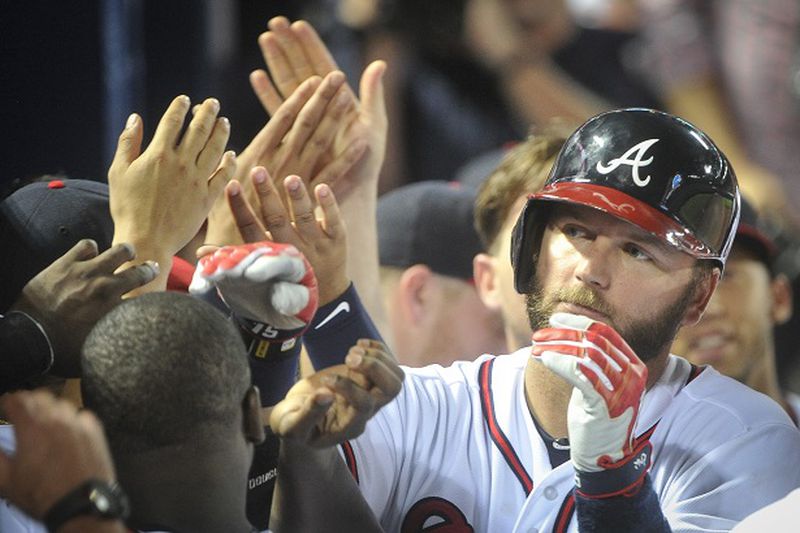Atlanta Braves' A.J. Pierzynski is congratulated in the dugout after his two-run homer to right field during the 9th inning of a baseball game against the San Francisco Giants,sending the game into extra innings, Monday, August 3, 2015, in Atlanta. (AP Photo/John Amis)