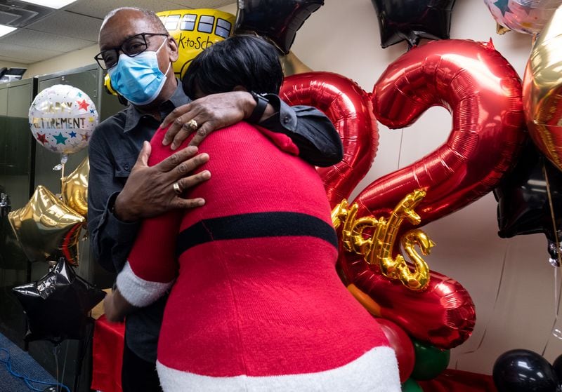 Charles Brown gets a hug from Janice Birt during a surprise celebration Friday, Dec. 18, 2020, to honor his retirement after 32 years of driving a school bus for Atlanta Public Schools. Ben Gray for the Atlanta Journal-Constitution