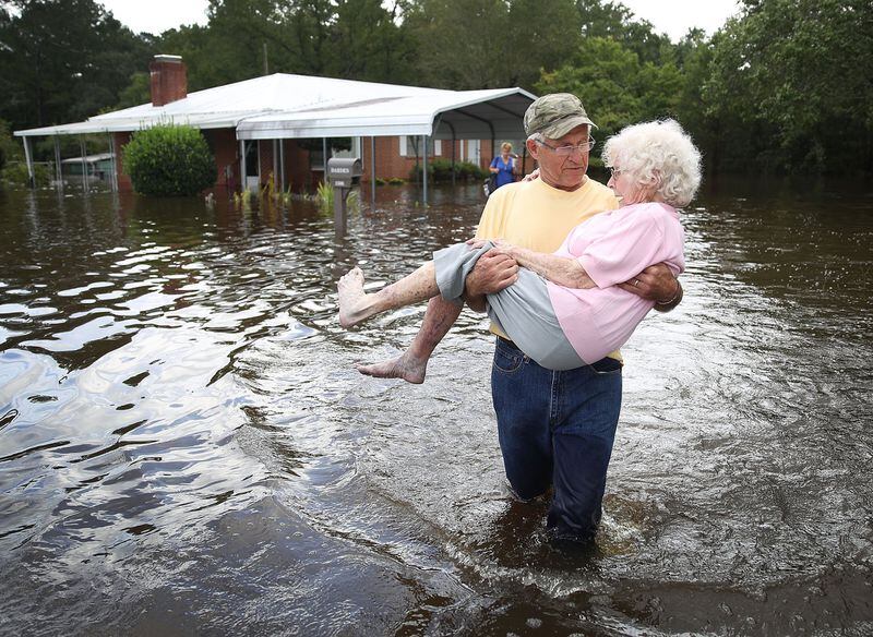 SPRING LAKE, NC - SEPTEMBER 17: Bob Richling carries Iris Darden as water from the Little River starts to seep into her home on September 17, 2018 in Spring Lake, North Carolina. Flood waters from the cresting rivers inundated the area after the passing of Hurricane Florence. (Photo by Joe Raedle/Getty Images) *** BESTPIX ***