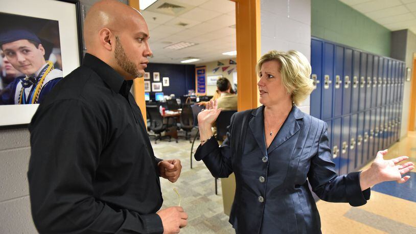 April 20, 2017 Marietta - Leigh Colburn (right), director of the Graduate Marietta Student Success Center, talks to Jose Mena, student behavior program specialist from Fulton County Schools, at the Graduate Marietta Student Success Center in Marietta High School on Thursday, April 20, 2017. Leigh Colburn has earned plaudits for her work with at-risk students at the 2-year-old Graduate Marietta Student Success Center, an experiment housed inside the city’s high school. Educators from across Georgia have made pilgrimages to the center, hoping to find ideas they can copy. HYOSUB SHIN / HSHIN@AJC.COM