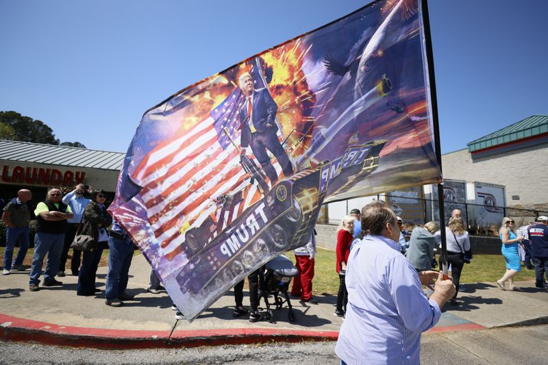 Supporters of former President Donald Trump rallied Thursday in the parking lot of the Adventures Outdoors gun store in Smyrna while his potential rival for the GOP presidential nomination in 2024, Florida Gov. Ron DeSantis, spoke inside. Miguel Martinez / miguel.martinezjimenez@ajc.com