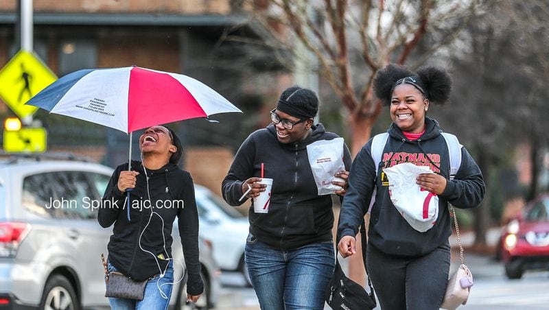 From left to right,  Kimberly Williams, 17, Joanna Mathis, 13, and Santonya Mathis, 16, walk in snow flurries in the 800 block of Glenwood Avenue. Any snow that falls Friday won't amount to much, according to Channel 2 Action News.