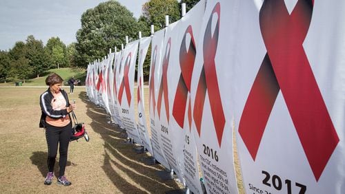 Maureen Robertson-Randall looks over the HIV/AIDS historical milestone display during the 27th Annual AIDS and 5K Run last October in Piedmont Park. Funders Concerned About AIDS has awarded grants to help fight the HIV epidemic in the South. STEVE SCHAEFER / SPECIAL TO THE AJC