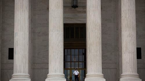 A Supreme Court Police officer stands at the top of the steps at the Supreme Court in Washington, D.C., U.S., on Monday, June 22, 2015. The U.S. Supreme Court is poised to issue blockbuster rulings on same-sex marriage and health care with both rulings due by the end of June as the court finishes its nine-month term with its traditional flurry of major opinions. Photographer: Drew Angerer/Bloomberg