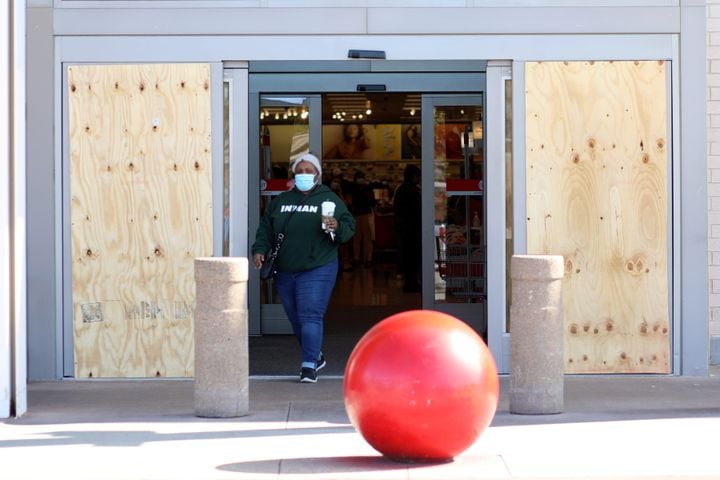 A person leaves Target at Edgewood Retail Center walks in thru a protected door with plywood sheets. Business around town are boarding up windows amid fears of unrest  related to the elections on Tuesday, Nov. 3, 2020, 
Miguel Martinez for The Atlanta Journal-Constitution